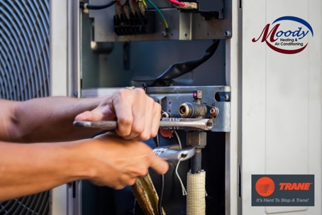 man tightening ac unit with wrenches